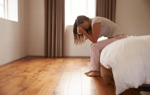 Une femme se tenant la tête entre les mains car elle est en dépression